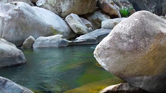 透明而清澈的水在石头河在山。热带雨林中一条平静的河流的光滑表面。河床上的石头。野生自然景观视频素材