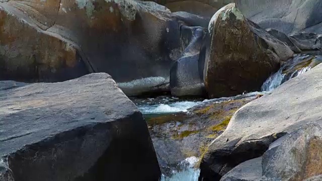 山河中的溪水倾泻在巨石上。水从山上的瀑布迅速地流进岩石河里。山间湍急的小溪视频素材