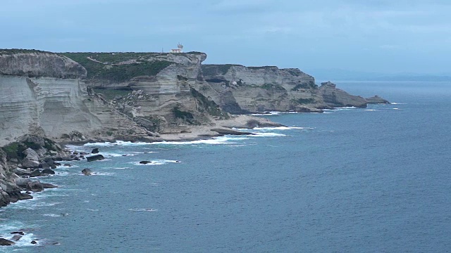 科西嘉海岸上的年轻女子在悬崖和海浪的慢镜头中视频素材