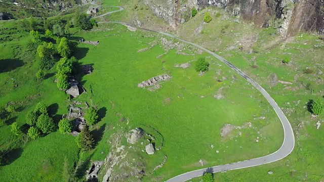 空中飞行:飞越意大利阿尔卑斯山脉上蜿蜒的山路，夏日冒险自驾游视频素材