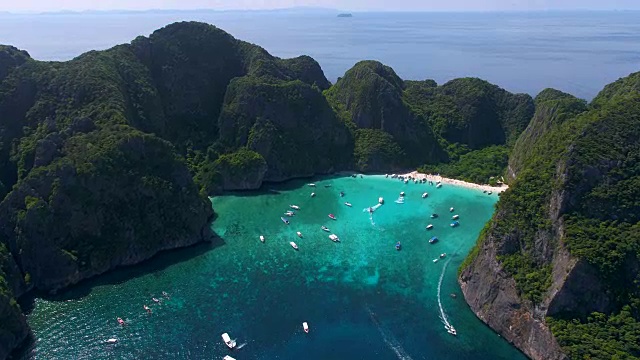 2018年5月16日，泰国玛雅湾。长尾船停泊在著名的玛雅湾和游客在海滩上视频素材