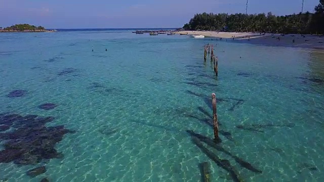 鸟瞰图的热带海滩，长尾船，皮划艇和岩石海岸与水晶清澈的绿松石水，泰国，沙顿视频素材