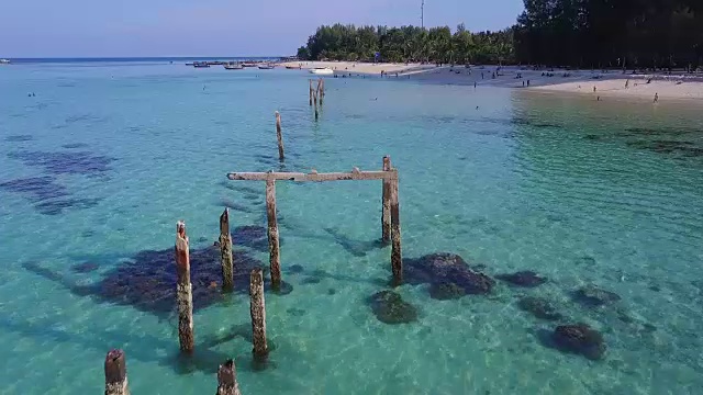 鸟瞰图的热带海滩，长尾船，皮划艇和岩石海岸与水晶清澈的绿松石水，泰国，沙顿视频素材