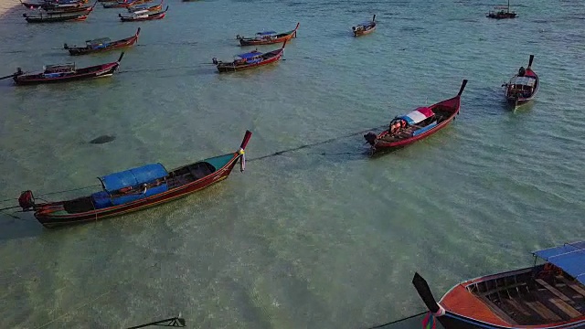 鸟瞰图跟踪长尾船和岩石海岸与水晶清澈的绿松石水Koh Lipe, Satun，泰国视频素材