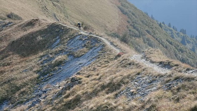 山地车在山里的一条小路上骑车下山。视频素材