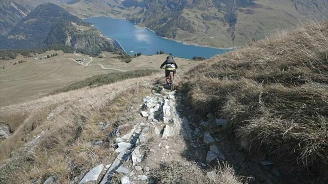 山地车在山里的一条小路上骑车下山。视频素材