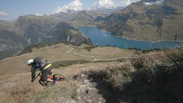 山地车在山里的一条小路上骑车下山。视频素材