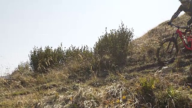 骑山地车的人在山区的岩石小道上骑车下山。——慢动作视频素材