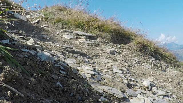 骑山地车的人在山区的岩石小道上骑车下山。——慢动作视频素材