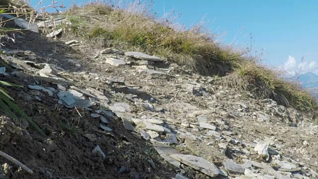 骑山地车的人在山区的岩石小道上骑车下山。视频素材