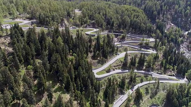 鸟瞰图山上蜿蜒的道路与卡车和汽车行驶在曲折起伏的欧洲瑞士4K视频素材