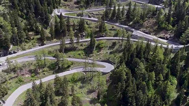 鸟瞰图山上蜿蜒的道路与卡车和汽车行驶在曲折起伏的欧洲瑞士4K视频素材