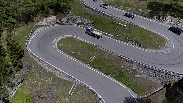 鸟瞰图山上蜿蜒的道路与卡车和汽车行驶在曲折起伏的欧洲瑞士4K视频素材