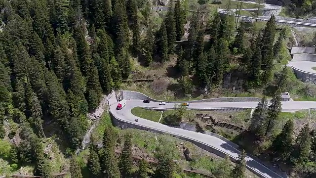 鸟瞰图山上蜿蜒的道路与卡车和汽车行驶在曲折起伏的欧洲瑞士4K视频素材