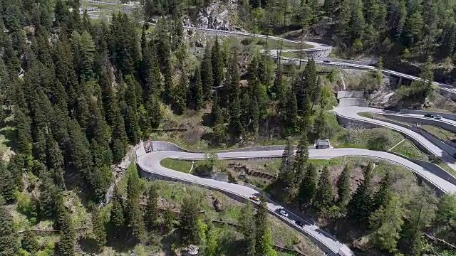 鸟瞰图山上蜿蜒的道路与卡车和汽车行驶在曲折起伏的欧洲瑞士4K视频素材