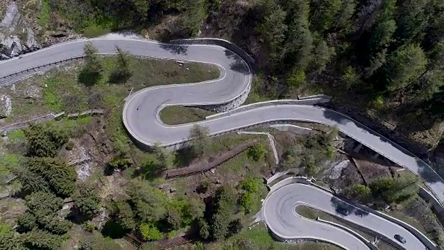 鸟瞰图山上蜿蜒的道路与卡车和汽车行驶在曲折起伏的欧洲瑞士4K视频素材