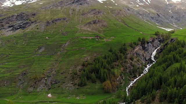 空中:飞越高山峡谷，风景如画的瀑布，雪山山脉和戏剧性的道路视频素材