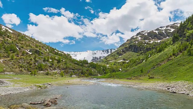 时光流逝:山间溪流流淌在绿色山谷中视频素材