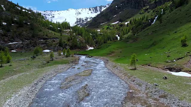 空中:飞越高山峡谷，风景如画的瀑布，雪山山脉和戏剧性的道路视频素材