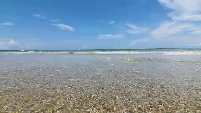 阳光明媚的泰国热带海景海滩，海浪拍打着沙滩，低角度视角，4K Dci分辨率视频素材