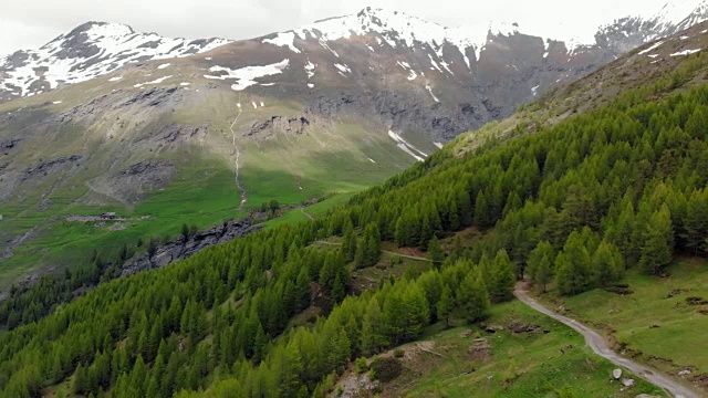 空中:飞越高山峡谷，风景如画的瀑布，雪山山脉和戏剧性的道路视频素材