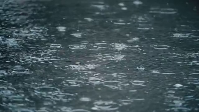 4K慢镜头拍摄雨落在人行道上。视频素材