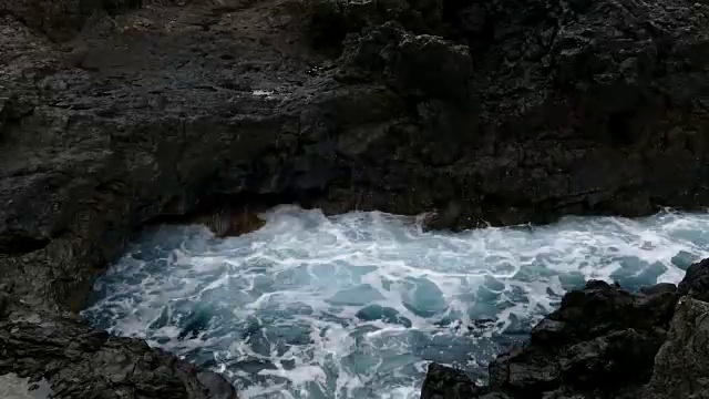 巨浪冲击着熔岩峭壁。时间流逝。视频素材