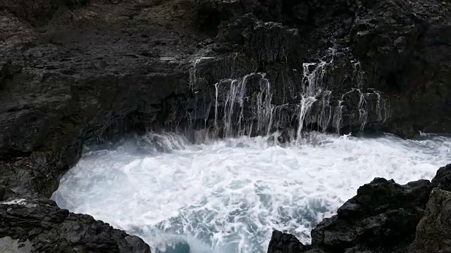 巨浪冲击着熔岩峭壁。视频素材