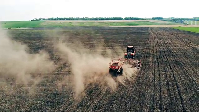 拖拉机在公路附近的田地里工作。视频素材