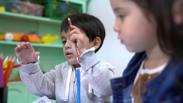 幼儿园的学龄前儿童在书上画画视频素材