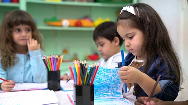 学前班女孩坐在教室里的朋友中间视频素材