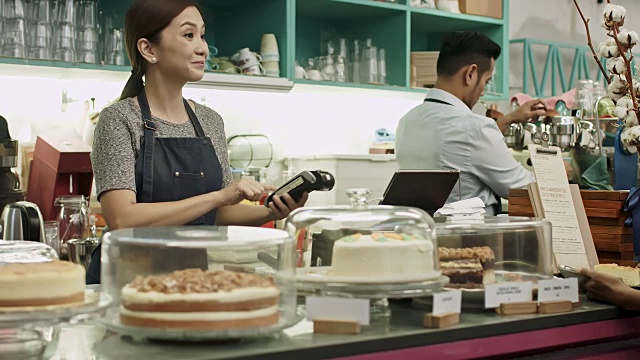 亚洲妇女在咖啡店点菜和付款视频素材