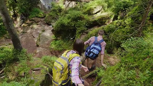 旅行者的朋友们小心翼翼地沿着陡峭的山路往下走视频素材