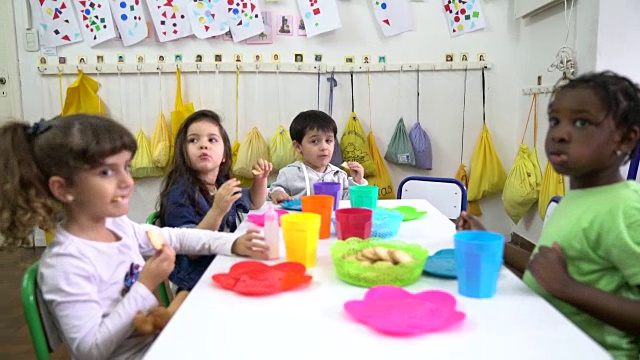 学前班学生在教室里吃饼干视频素材