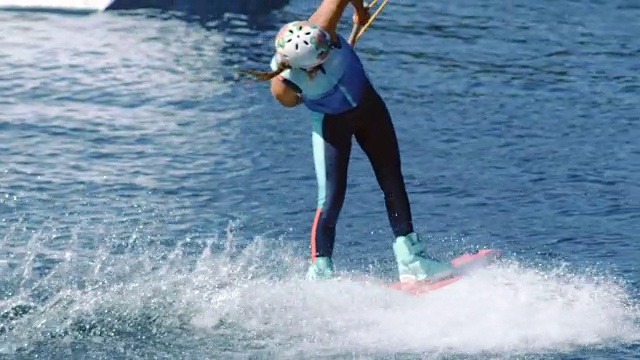 年轻女子在夏天的河里玩尾流板。水上娱乐视频素材