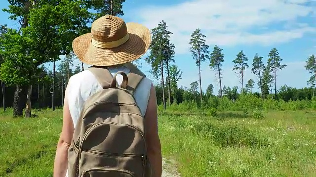 一个女人走在林中的小路上视频素材