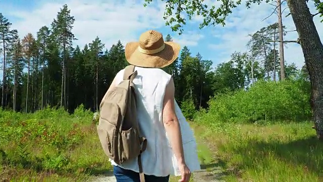 一个女人走在林中的小路上视频素材