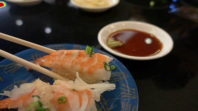 在日本餐厅酒吧里，用寿司拉近筷子的距离视频素材