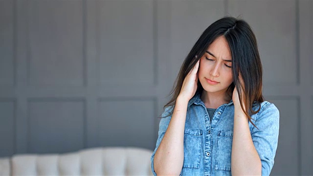 饱受压力或头痛折磨的女性在家痛苦地扮鬼脸视频素材