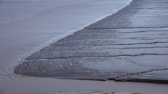 水沿着泥滩的边缘流动视频素材