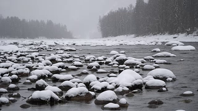 大雪期间山区河流上的冬季景象。视频素材