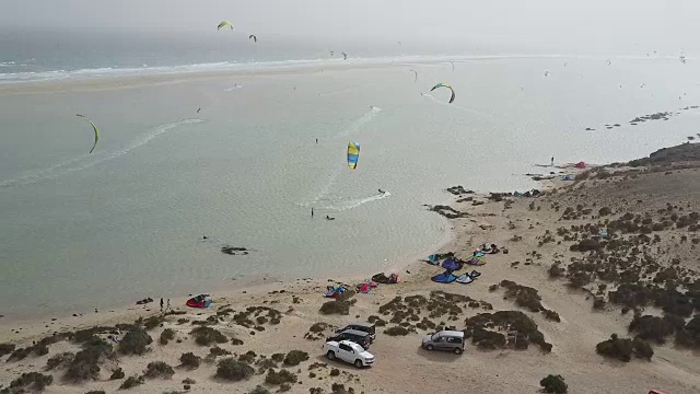 风筝冲浪者风筝点缀在富埃特文图拉海滩附近的天空视频素材