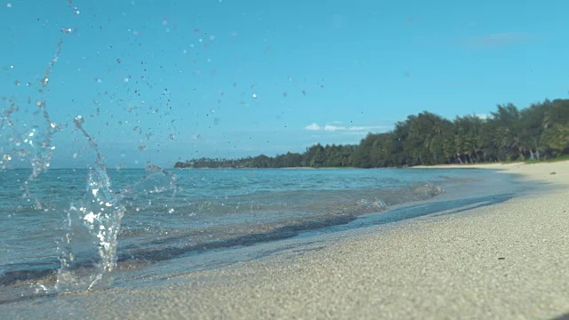 慢镜头:一个活跃的年轻人在潮湿的沙滩上慢跑。视频素材