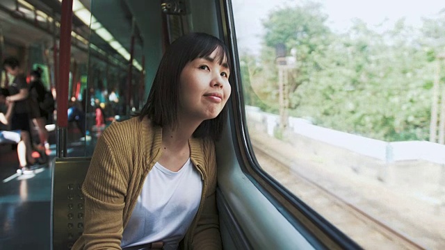 迷人的女人看着窗户，探索外面的风景视频素材