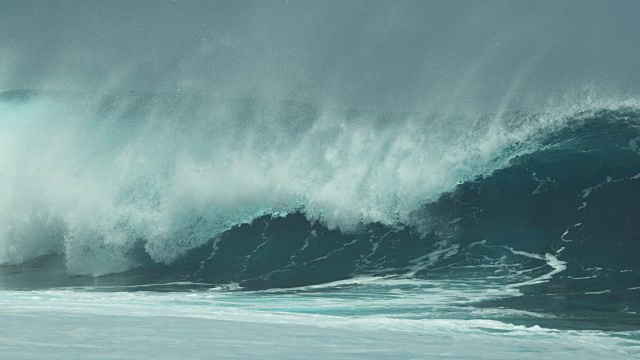 慢镜头:当桶状海浪冲向海岸时，水滴在阳光下闪烁视频素材