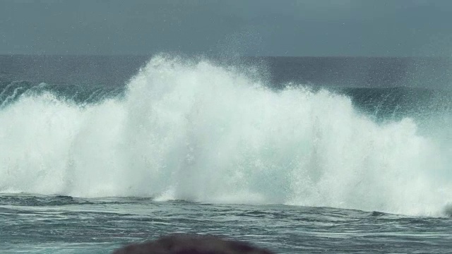 慢镜头:当海浪撞击时，晶莹剔透的海水滴落在空中。视频素材