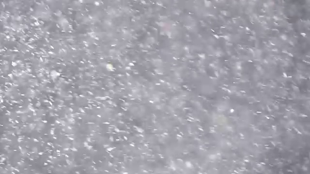 阳光灿烂的暴风雪与闪闪发光的彩色雪花。抽象的闪光背景在慢动作。视频素材