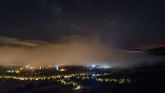 星星与银河和波浪的薄雾在夜晚村庄时间流逝视频素材