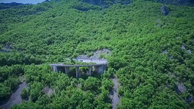 鸟瞰图一个弯曲的道路与汽车通过。山路视频素材