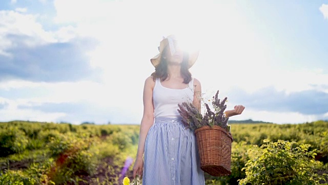 美丽的女人拿着花篮享受大自然视频素材